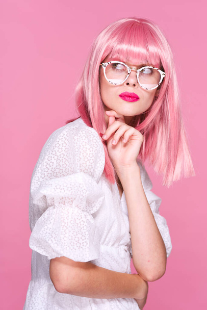 Studioaufnahmen. Junges Mädchen mit rosa Perücke und Brille auf rosa Hintergrund - Foto, Bild