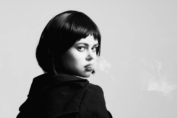 Porträt einer jungen schönen Frau beim Rauchen  - Foto, Bild