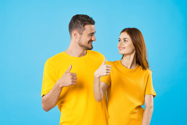 young woman and man with thumbs up  on blue background  - Photo, Image
