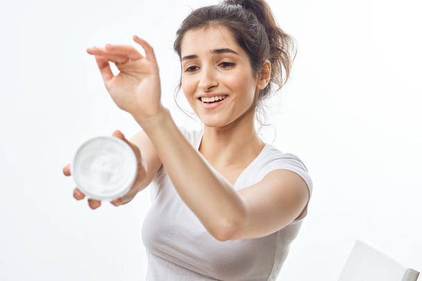   young beautiful woman applying hand cream in studio on isolated background           - Photo, Image