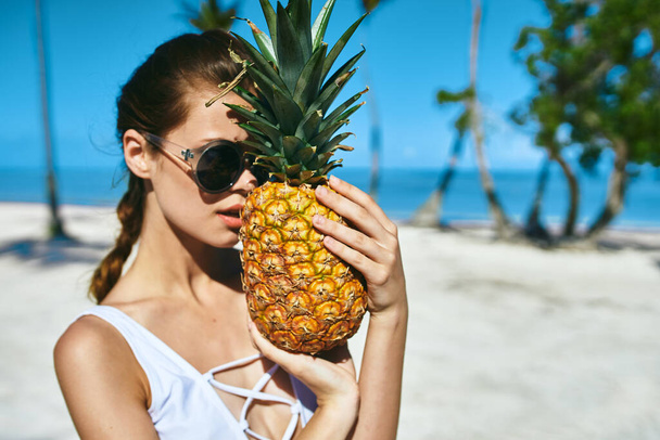 Kobieta w białym stroju kąpielowym z ananasem. Wysokiej jakości zdjęcie - Zdjęcie, obraz