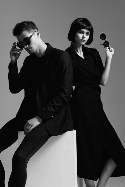 junge schöne stilvolle Paar mit Sonnenbrille posiert im Studio, isoliert - Foto, Bild