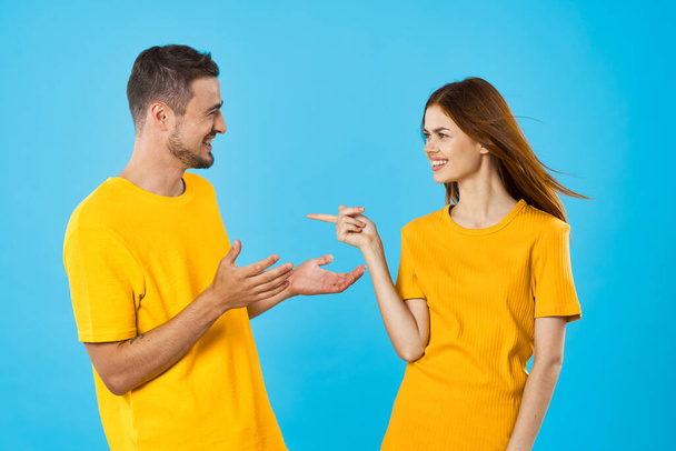 νεαρός όμορφος άντρας και γυναίκα μιλούν στο στούντιο σε μπλε φόντο  - Φωτογραφία, εικόνα