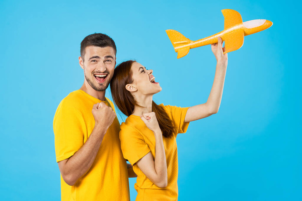 young  couple with toy airplane  in studio, isolated background    - Photo, Image