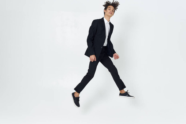 young handsome businessman  jumping in studio                     - Foto, afbeelding