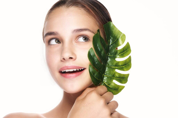 Young beautiful woman posing  with  leaf in studio - Fotografie, Obrázek