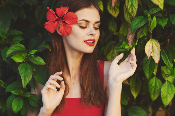 mladá krásná žena s červeným květem v zahradě                           - Fotografie, Obrázek