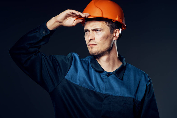 Студийный снимок Промышленный рабочий в оранжевом шлеме смотрит вдаль  - Фото, изображение