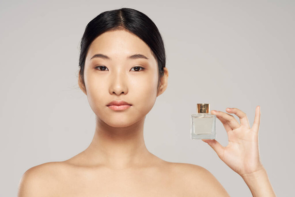 young beautiful  asian woman with perfume - Фото, изображение