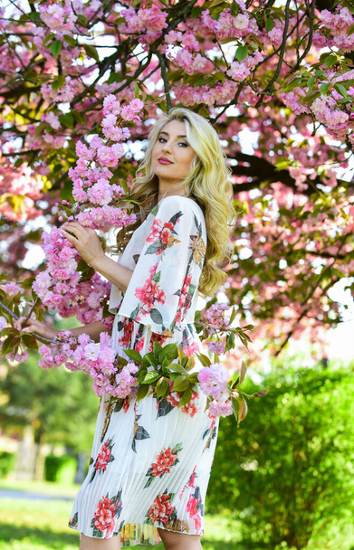 Spring blossom. Happy spring day. Spring symbol. Girl enjoy sakura in garden. Cherry tree. Good vibes. Floral aroma. Reasons why flowers always make women happy. Perfume and cosmetics. Self care - Фото, изображение