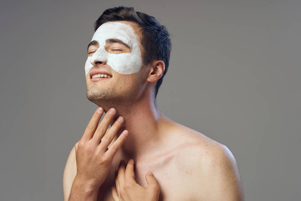 Young handsome man with face mask smiling    in studio  - Foto, Imagem