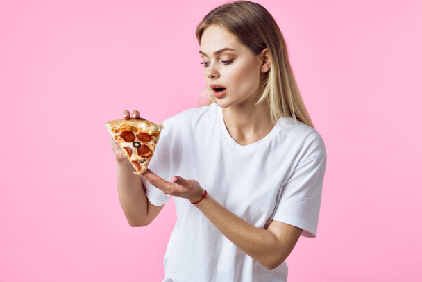 İzole edilmiş arka planda pizza yiyen genç ve güzel bir kadın.  - Fotoğraf, Görsel