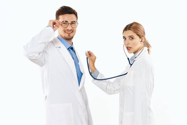 Młodzi lekarze w studiu, odizolowani. kobieta ze stetoskopem - Zdjęcie, obraz