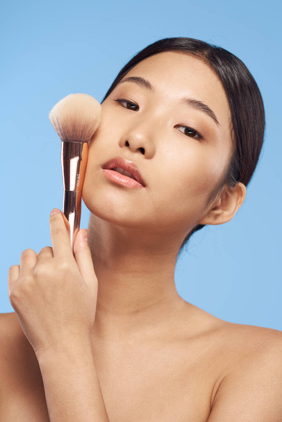 Retrato de bela mulher asiática com escova no fundo isolado  - Foto, Imagem