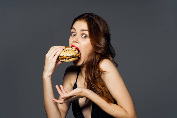 Young beautiful woman with hambyrger. Studio shot - Foto, Bild