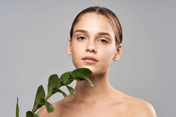 Young beautiful woman posing  with  leaf in studio - Photo, Image