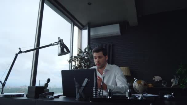 Positive businessman talking with business partner during video chat in office - Footage, Video