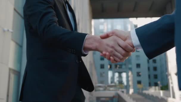 Primo piano delle mani dei top manager in giacca e cravatta, stringere la mano tra di loro, in Business center sfondo, accettare un accordo o dire ciao. - Filmati, video