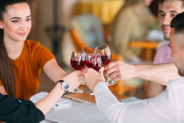 Friends drink wine on the terrace of the restaurant. - Foto, Imagen