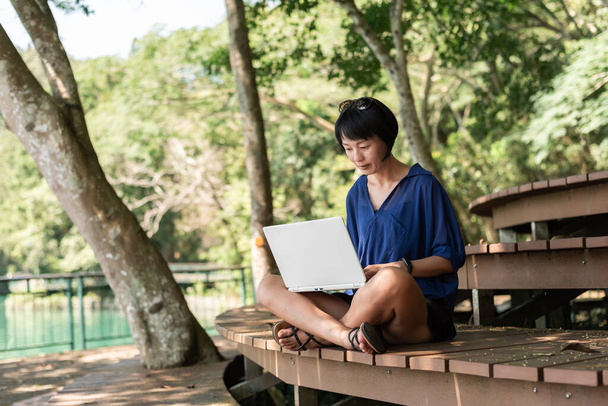 nainen käyttää kannettavaa tietokonetta, käsite työskentely ulkona - Valokuva, kuva