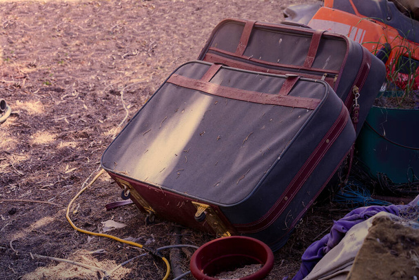 Старые выветриваемые чемоданы, брошенные среди прочего хлама - Фото, изображение