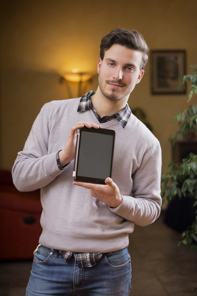 Joven guapo en casa con tableta PC en sus manos - Foto, imagen