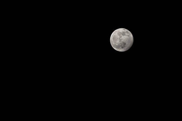 Luna llena en un cielo negro sin nubes. Un satélite natural. Un satélite natural en el espacio, una vista desde la Tierra. - Foto, Imagen