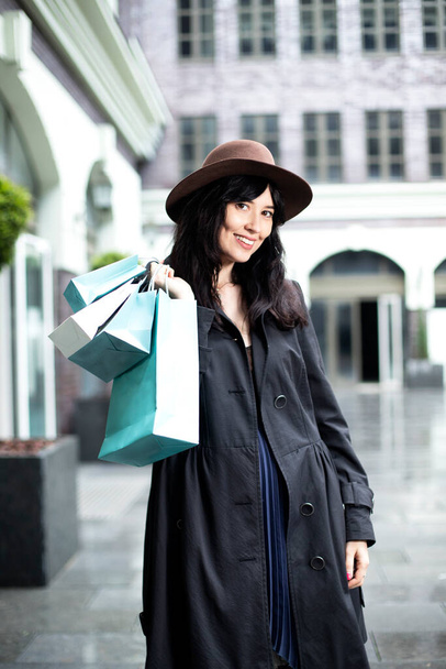 όμορφο κορίτσι με τσάντες στις οποίες οι αγορές από τα καταστήματα - Φωτογραφία, εικόνα