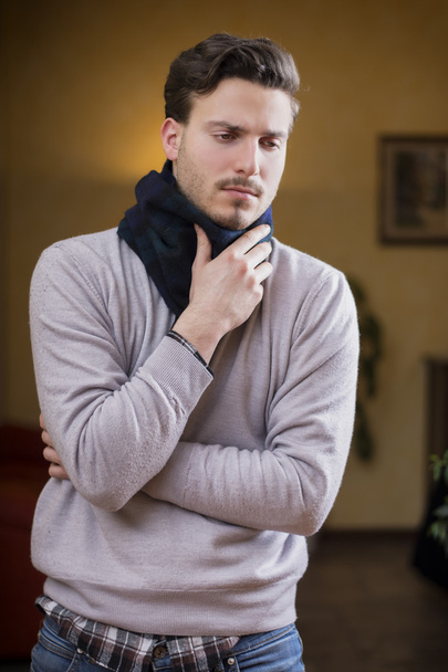 Young man with scarf, holding his neck because of throat ache - Φωτογραφία, εικόνα