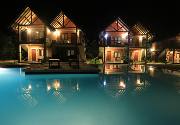 нічна сцена з басейном і будинками
 - Фото, зображення