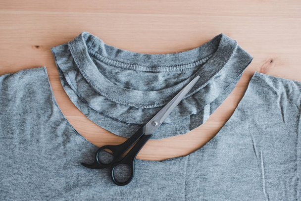 fashion diy and upcycling old clothes concept, t-shirt with scissors to cut a new neckline  - Fotografie, Obrázek