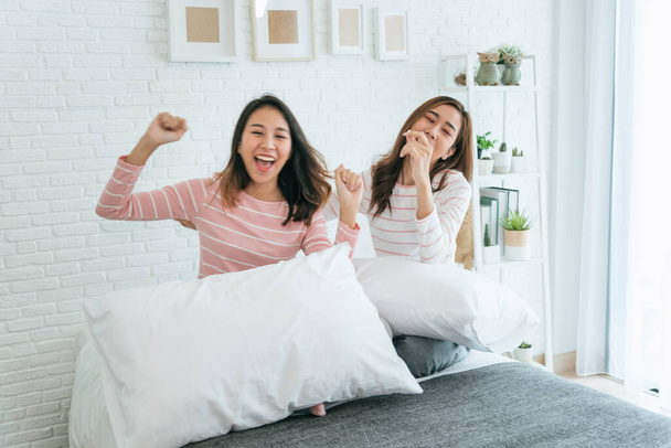 Two pretty best friends forever girlfriend talk, hug and laugh together on bed at cozy home relation fall in love. Lesbian couple homosexual happy lifestyle on bed. LGBTQ relation lifestyle concept. - Foto, Imagem