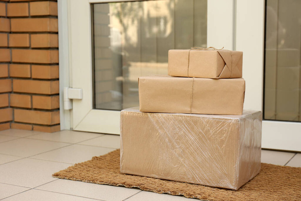 Delivered parcels on door mat near entrance - Fotoğraf, Görsel