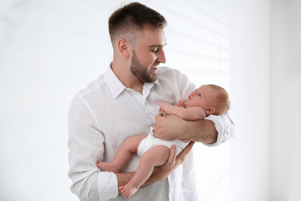 Father with his newborn son on light background - Photo, Image