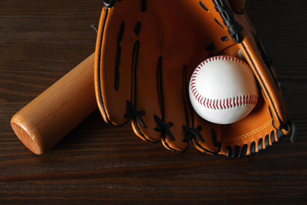 Leather baseball ball, bat and glove on wooden table - Фото, изображение