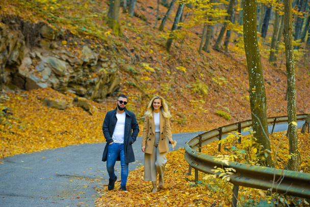 Young couple walking in the autumn park. - Valokuva, kuva