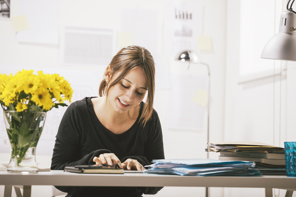 Young casual woman using digital tablet in office. - Foto, imagen