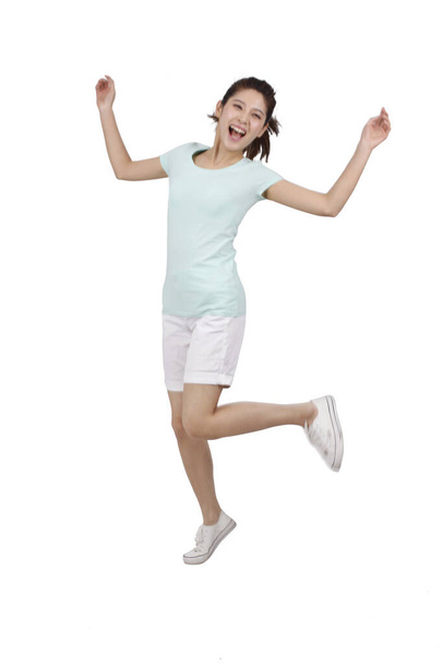 Young woman jumping  on white background - Valokuva, kuva