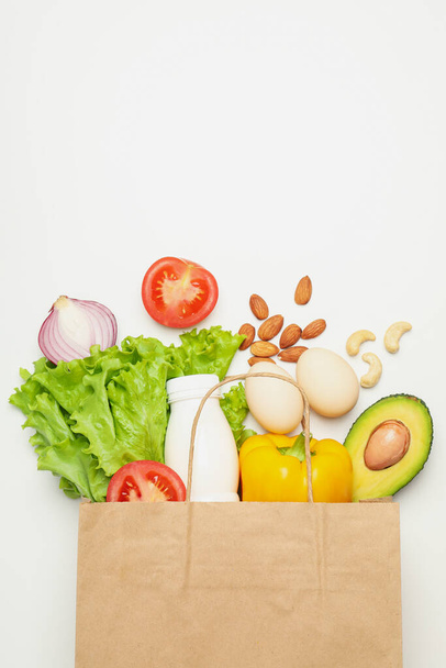 Paper bag with different food on white background - Photo, Image