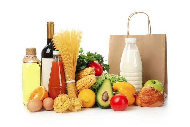Бумажный пакет и различные продукты питания изолированы на белом фоне - Фото, изображение