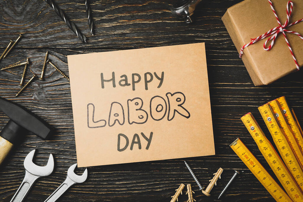 Text Happy Labor day and construction tools on wooden background - Fotografie, Obrázek