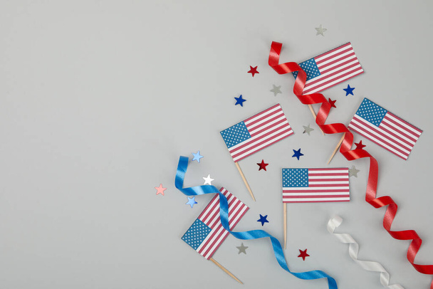 Amerykańskie flagi, kręcone wstążki i gwiazdy na szarym tle - Zdjęcie, obraz