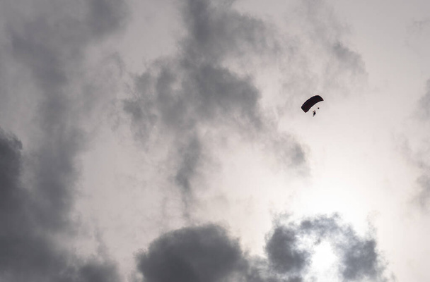 Силуэт парашютиста в полете до заката - Фото, изображение