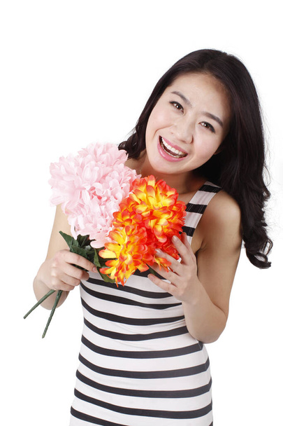	Young woman in a striped dress holding flowers	 - Фото, изображение