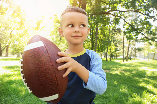 Little boy playing American football outdoors - Φωτογραφία, εικόνα