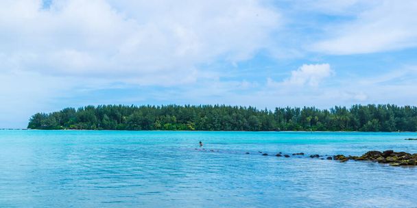 Moorea, French Polynesia: 09 / 03 / 2018: Moorea is a tropical Island with blue ocean and yellow sand. Poeple проводят свое время плавая и прогуливаясь по пляжу. Всегда лето.. - Фото, изображение