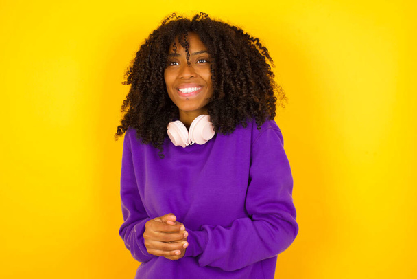 African american female  smiles in excitement on yellow background. Emotions and gestures concept - Valokuva, kuva