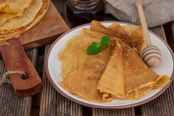 Zelfgemaakte zoete dunne zuurdesem pannenkoeken crêpes geserveerd met honing - Foto, afbeelding