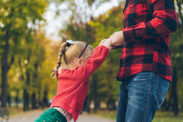 秋の市公園で遊んでいる小さな娘を持つ父親 - 写真・画像