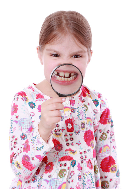 Girl show teeth through a magnifying glass - Valokuva, kuva